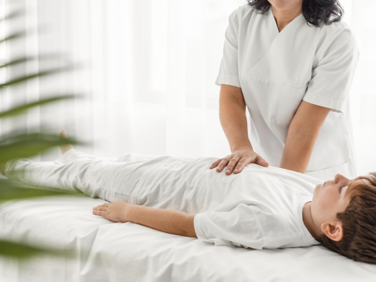 osteopathist-treating-kid-by-massaging-him-hospital